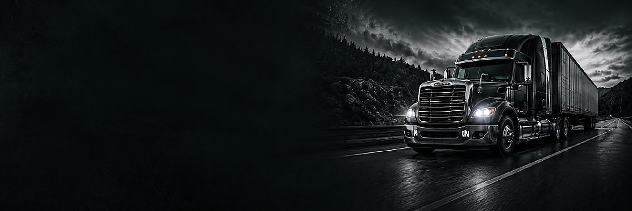 Semi truck with headlights on driving at night